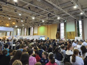 A képen a résztvevő tömeg látható amint az előadót hallgatják.