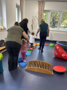 A képen a tornaszobában felállított mozgásfejlesztő akadály pályát használják a gyerekek a pedagógusok és a szülők segítségével.