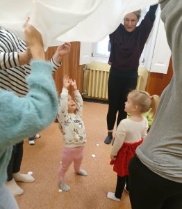 A képen a gyermekek a szülőkkel közösen játszanak.