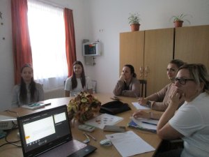 Hallgatóság: A képen egy irodában nagy kerek asztal körül ülnek az óvónők és hallgatják az előadást.