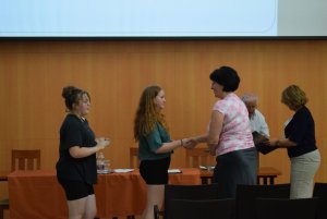 A képen két tanuló veszi át könyvjutalmát.