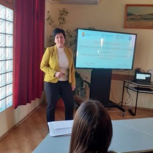 A képen Zsoldos Erzsébet, intézményünk főigazgatója tartja bemutatóját a tanulóknak az interaktív tábla előtt állva. 