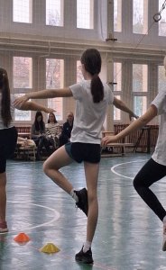 A képen egy gyermek háttal a fényképésznek végzi a tornagyakorlatot. 