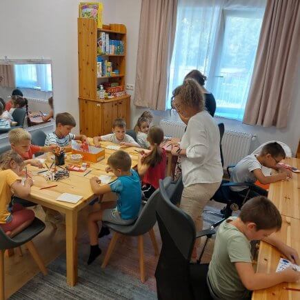 A képen a Tábor résztvevői az asztalokat körbe ülve készítik saját névtábláikat.