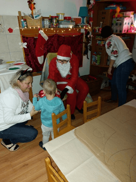 A kép egy kisgyermek és a Mikulás találkozását és az ajándék csomag átadását örökítette meg.