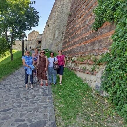 A képen a Tiszafüredi Tagintézmény munkatársai láthatóak egy csoportképen az Egri várfal tövében.