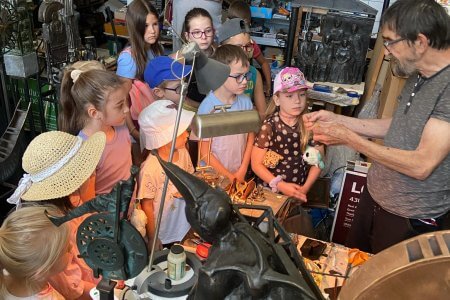 A képen a Művésztelep szobrászműhelyében az előadót figyelmesen hallgatják a gyermekek.