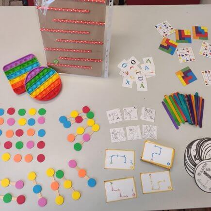 A képen több otthon is elkészíthető és használható részképesség fejlesztő eszköz látható.