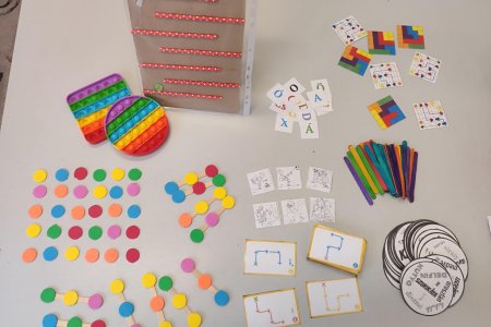 A képen több otthon is elkészíthető és használható részképesség fejlesztő eszköz látható.