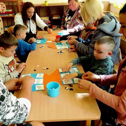 A képen logopédiai eszközök készítésének folyamata látható a szülők és a gyermekek bevonásával.