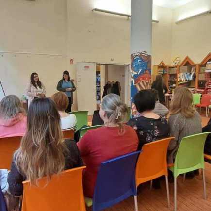 A képen az előadás egyik pillanata látható amint a résztvevők a kamerának háttal ülve, arccal az előadók felé figyelmesen hallgatják az előadást, amit a képen is látható két előadó tart egy tábla mellett állva.