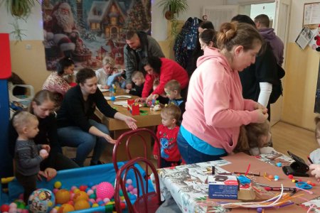 A képen a szülők és gyermekek kézműveskednek a Mikulás ünnepségen.
