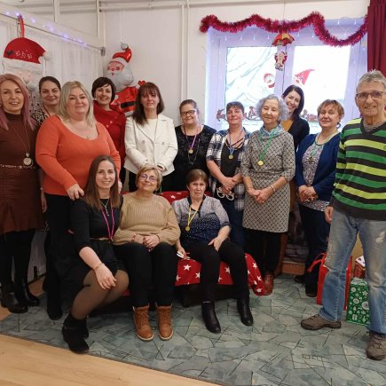 A képen a JNSZV Pedagógiai Szakszolgálat Kunszentmártoni Tagintézményének munkatársai láthatóak a fenyőfa mellett egy csoportképen.