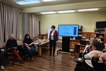 A képen intézményünk Főigazgatója az interaktív tábla előtt állva tájékoztatja a körülötte helyet foglaló szülőket az intézmény működéséről és a jelenlegi pályázati programjainkról.