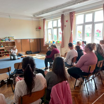 A képen a nyílt nap résztvevői láthatóak ahogy a székeken helyet foglalva hallgatják a velük szemben helyet foglaló előadót.