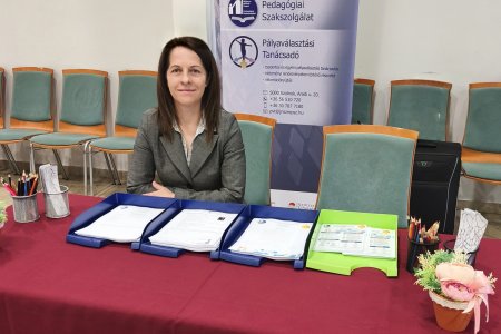 A képen a Szakmák Piacán felállított, Pályaválasztási Tanácsadói stand látható amely mögött kolléganőnk helyet foglalva várja az érdeklődőket.